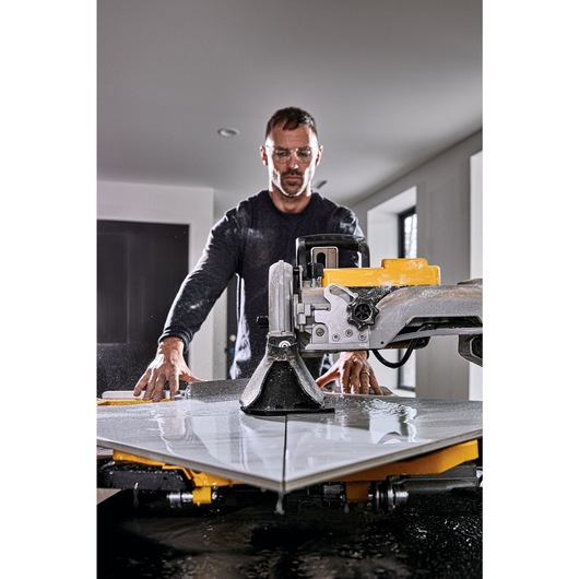 High Capacity Wet Tile Saw being used by a person to cut tile High Capacity Wet Tile Saw being used by a person to cut tile