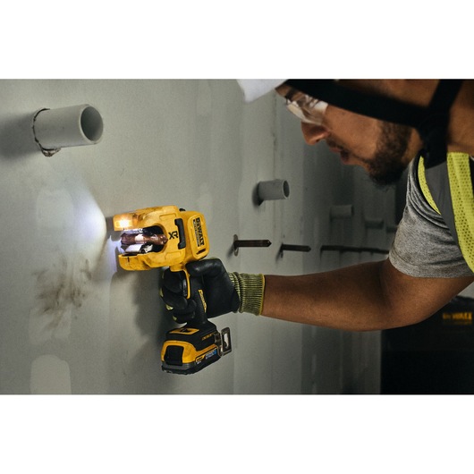 DEWALT 18V XR Brushless Copper Tubing Cutter being used to cut copper pipe stub from wall