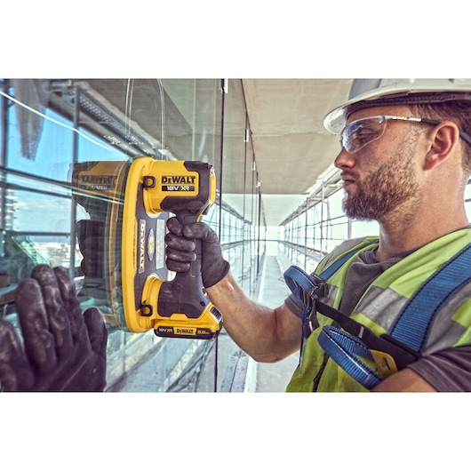 Construction worker attaches a Grabo 18V XR Suction Lifter to a pane of glass