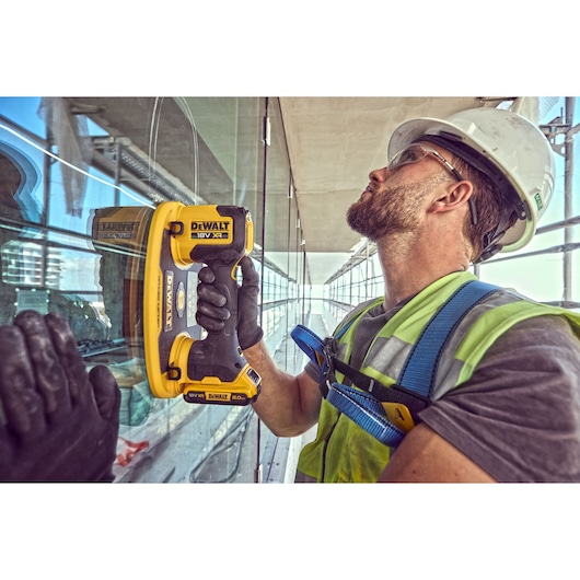 Construction worker holds a Grabo 18V XR Suction Lifter attached to a pane of glass