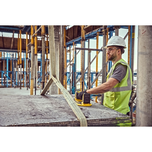 Construction worker uses a  Grabo 18V XR Suction Lifter to guide a large delivery of timber sheeting