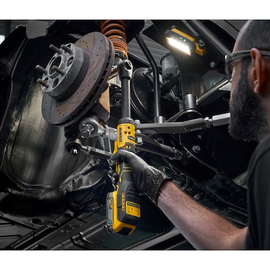 Mechanic using the DEWALT 18V XR Brushless _� Extended Ratchet with 18V POWERSTACK battery to tighten bolts on engine