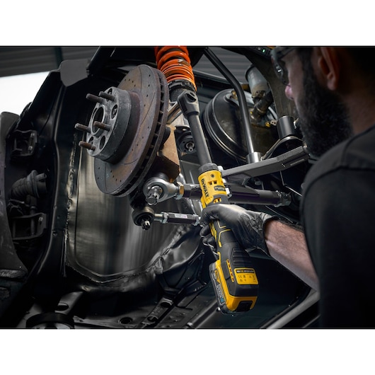 Mechanic using the DEWALT 18V XR Brushless _� Extended Ratchet with 18V POWERSTACK battery to tighten bolts on engine