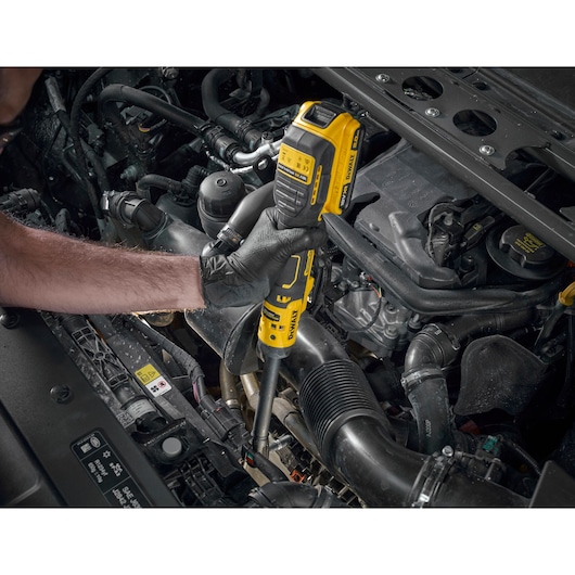 Mechanic using the DEWALT 18V XR Brushless _� Extended Ratchet with 18V POWERSTACK battery to tighten bolts on engine