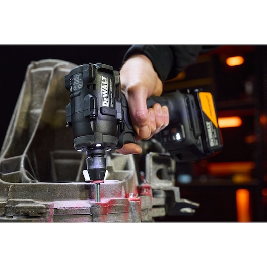 DEWALT x McLaren F1 Team 18V XR Special Edition Compact Impact Wrench with 5Ah battery tightening a bolt