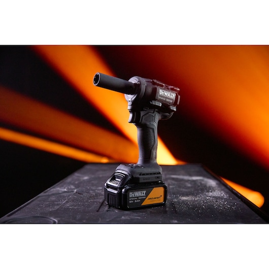 DEWALT x McLaren F1 Team 18V XR Special Edition Compact Impact Wrench with 5Ah battery standing on a storage box