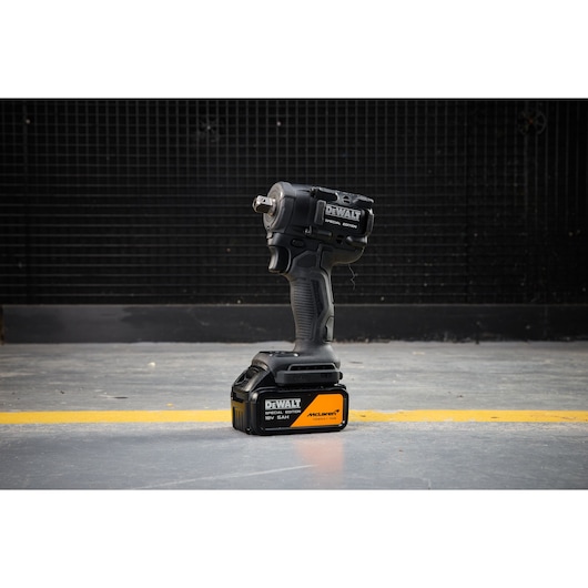 DEWALT x McLaren F1 Team 18V XR Special Edition Compact Impact Wrench with 5Ah battery standing on a concrete floor