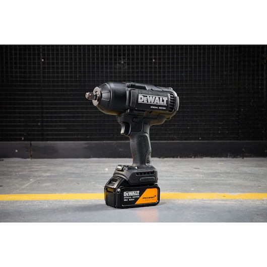 DEWALT x McLaren F1 Team 18V XR Special Edition Impact Wrench with 5Ah battery standing on a concrete floor