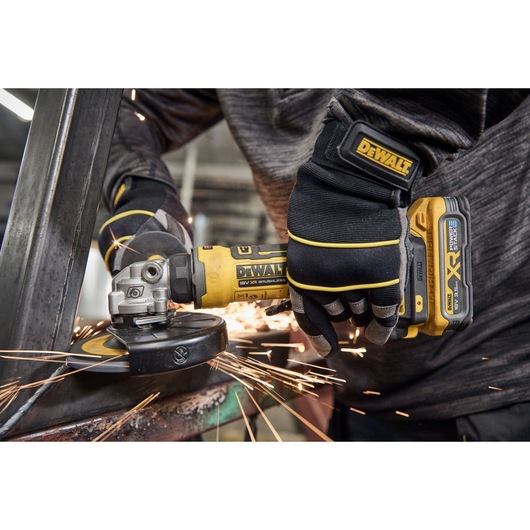 Worker uses the DEWALT 18V XR Compact 125mm Angle Grinder to grind steel square tubing