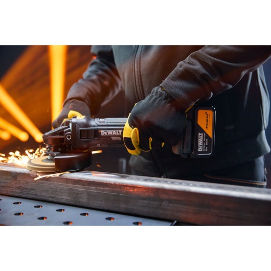 DEWALT x McLaren F1 Team 18V XR Special Edition Grinder with 5Ah battery grinding a metal bar
