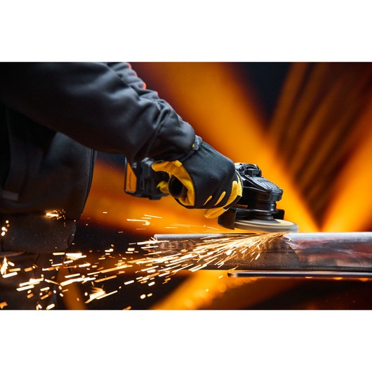 DEWALT x McLaren F1 Team 18V XR Special Edition Grinder with 5Ah battery grinding a metal bar