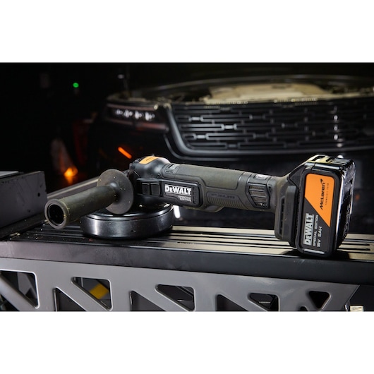 DEWALT x McLaren F1 Team 18V XR Special Edition Grinder with 5Ah battery in an auto mechanic setting