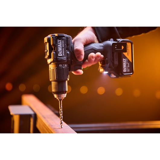 DEWALT x McLaren F1 Team 18V XR Special Edition Hammer Drill Driver with 5Ah battery drilling a metal bar