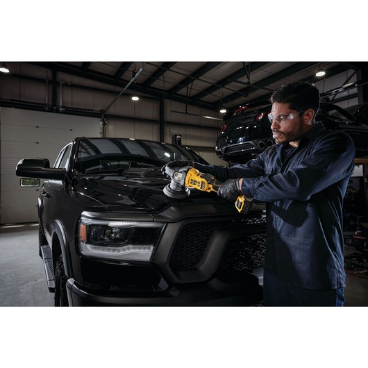 cordless variable speed random orbit polisher being used by a person to polish a car