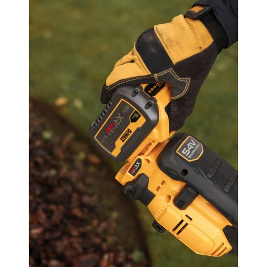 A DEWALT 9Ah FLEXVOLT battery being atatched to a DEWALT 54V XR FLEXVOLT Split Boom