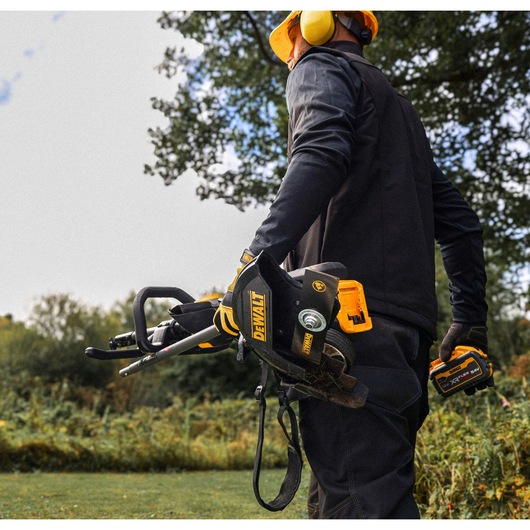 Woker carries a folded DEWALT 54V XR FLEXVOLT Split Boom with Edger Attachment