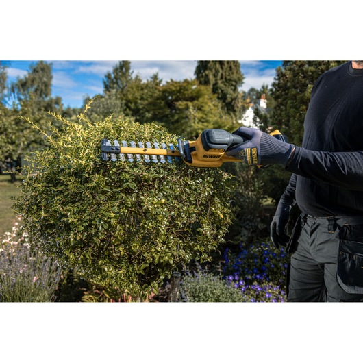 The DEWALT 18V XR Compact Hedge Trimmer  in action