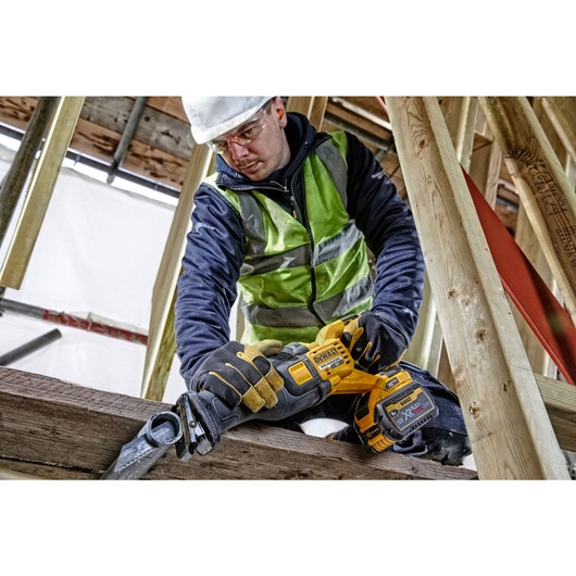 FLEXVOLT brushless cordless reciprocating saw being used by person to cut pipe.