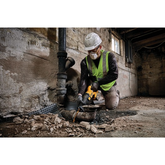 FLEXVOLT brushless cordless reciprocating saw being used by person on wood.