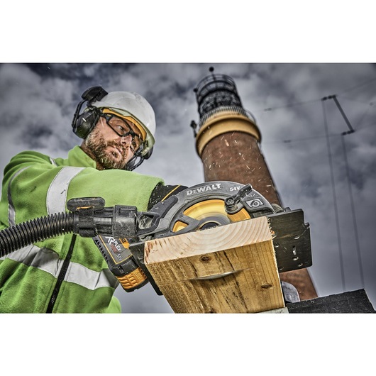 FLEXVOLT brushless cordless circular saw with brake kit being used by person on wooden plank.