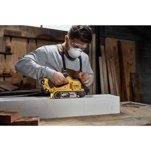 18V XR Brushless Belt Sander sanding a white wooden case