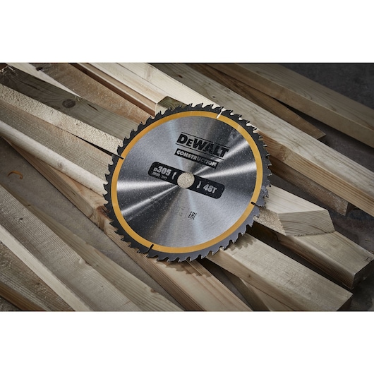 E1	Close up of 305mm circular saw blade sitting on top of wood