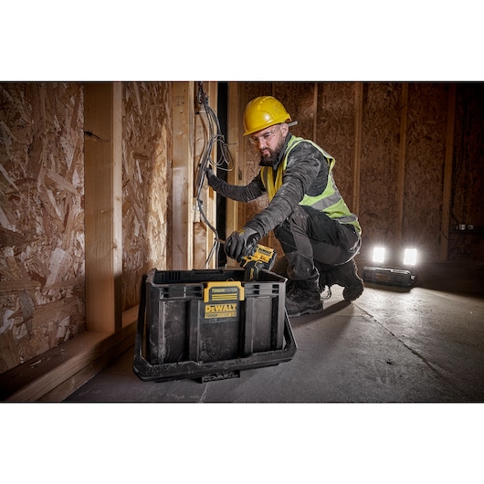 TOUGHSYSTEM 2.0 Cordless Adjustable Work Light and Storage on floor job site helping worker