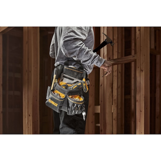 Person wearing the Dewalt Pro Nail Pouch. The pockets are filled with nails and tools.