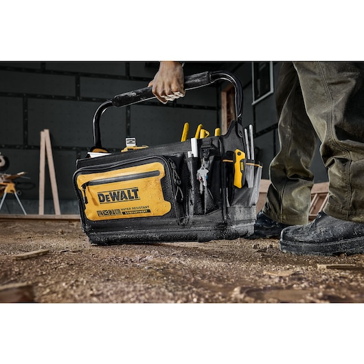 Dewalt 20" Pro Tool Tote being placed on the ground of a construction site"