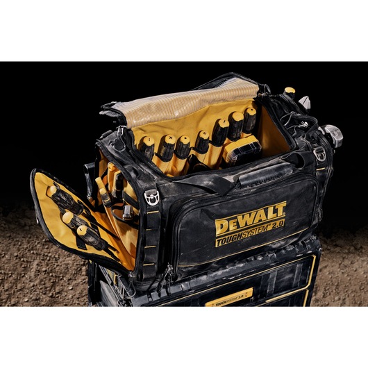 Three quarter view of open DEWALT TOUGHSYSTEM 2.0 22-inch jobsite soft storage toolbag holding DEWALT screwdrivers and other hand tools.