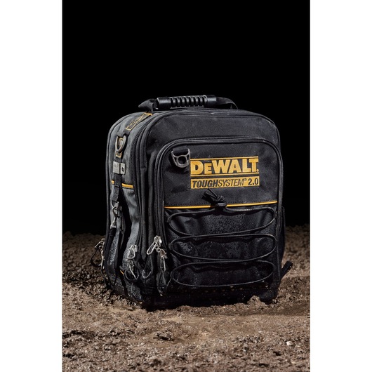 Front view of closed DEWALT TOUGHSYSTEM 2.0 11-inch compact soft storage toolbag sitting on wet dirt.