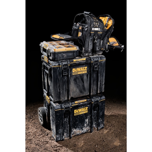 Three quarter view of DEWALT TOUGHSYSTEM 2.0 11-inch compact soft storage toolbag holding multiple hand tools sitting next to a half-size TOUGHSYSTEM 2.0 organizer on a TOUGHSYSTEM 2.0 mobile storage toolbox.