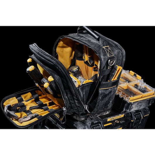 Front view of open DEWALT TOUGHSYSTEM 2.0 11-inch compact soft storage toolbag holding multiple hand tools sitting on a TOUGHSYSTEM 2.0 mobile storage toolbox.