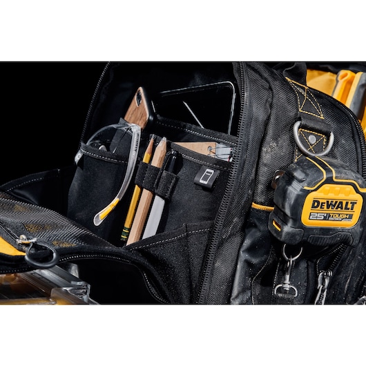 Front view of DEWALT TOUGHSYSTEM 2.0 11-inch compact soft storage toolbag holding multiple hand tools including a 25 ft. DEWALT TOUGHSERIES tape measure.